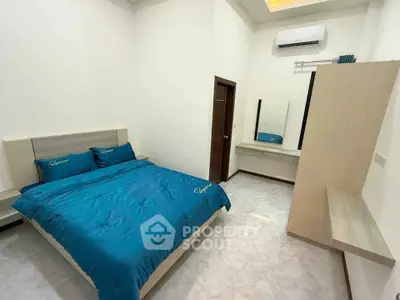 Modern bedroom with stylish blue bedding and sleek furniture design.
