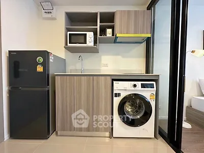 Modern compact kitchen with washing machine and fridge in stylish apartment