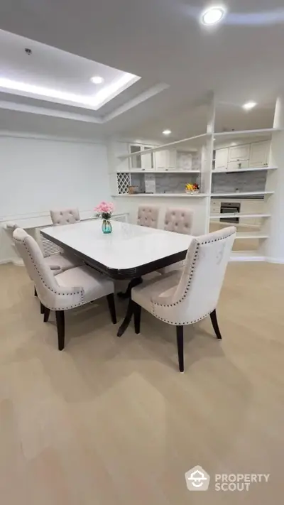 Elegant dining area with plush chairs and modern kitchen in open layout design