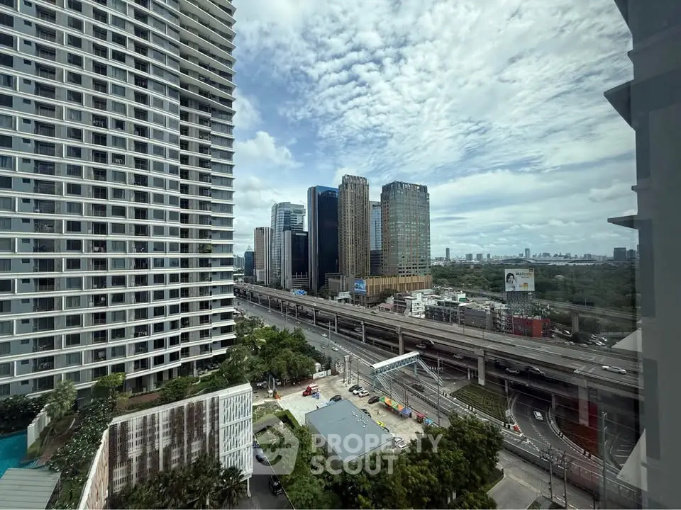 Stunning cityscape view from high-rise building with modern architecture and lush greenery.