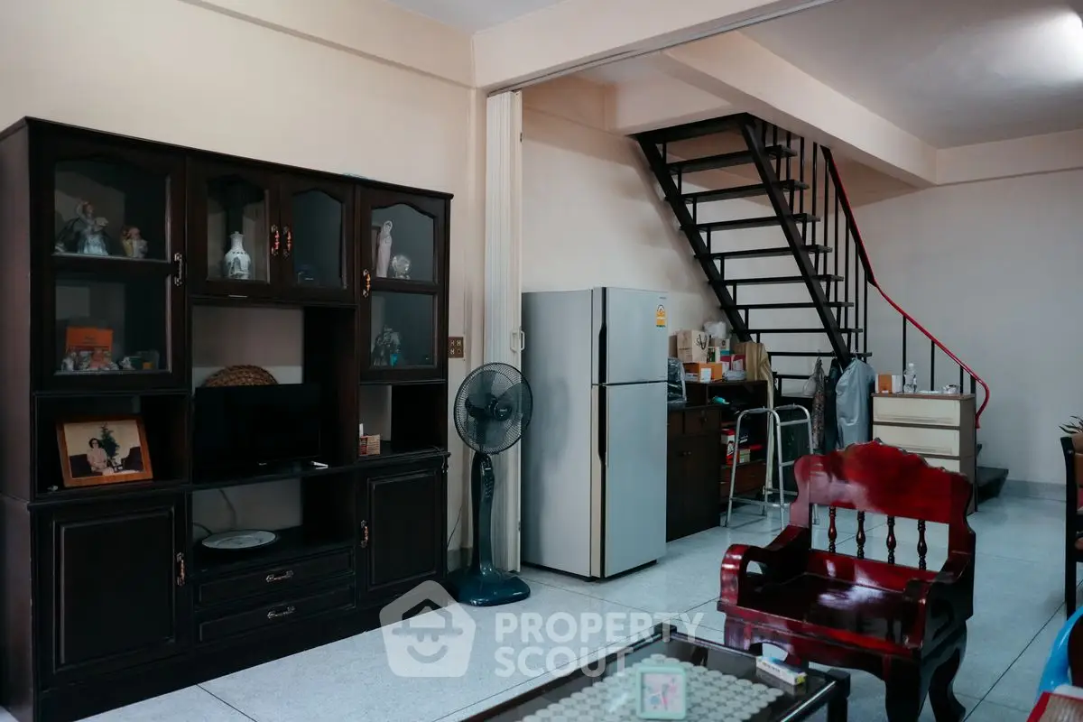 Charming living room with staircase and modern appliances, perfect for cozy family gatherings.