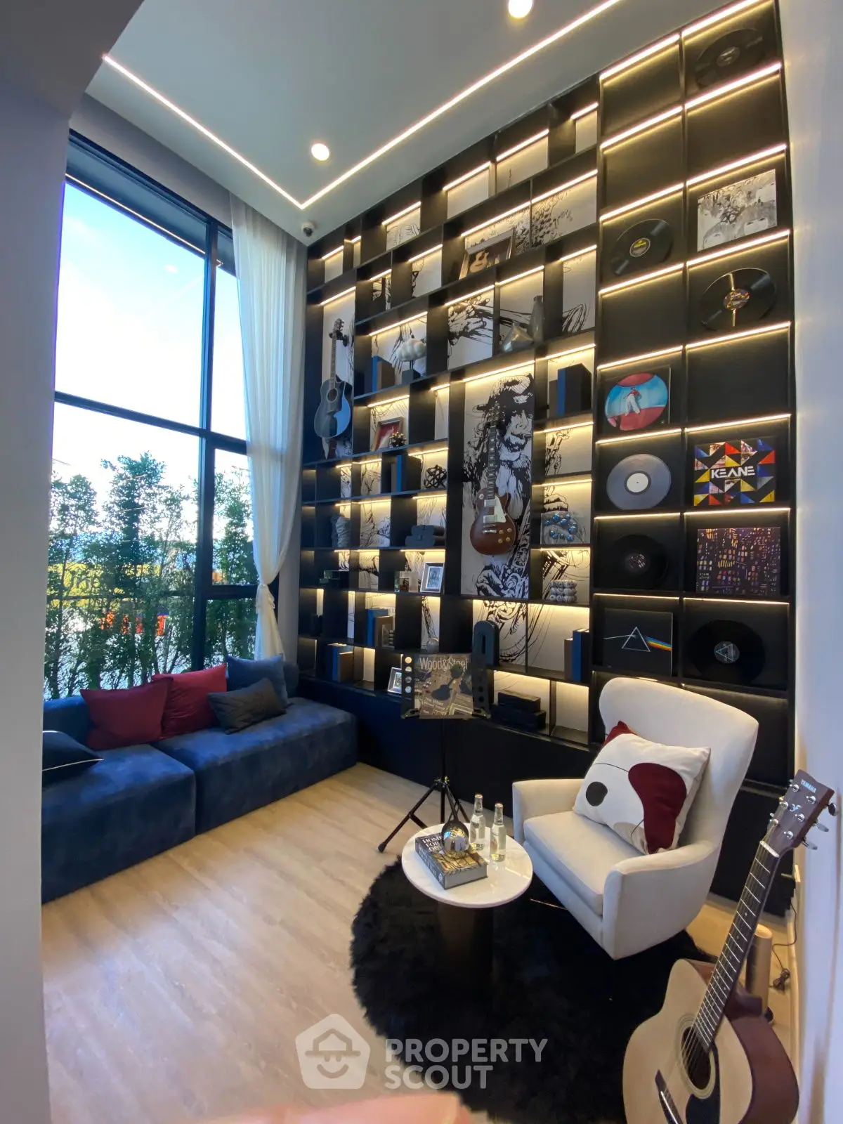 Stylish music-themed living room with high ceilings and large window
