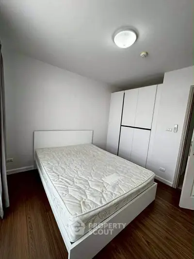 Modern bedroom with minimalist design featuring a comfortable bed and sleek wardrobe.