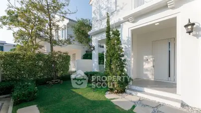 Charming white exterior with lush garden and inviting entrance in modern home