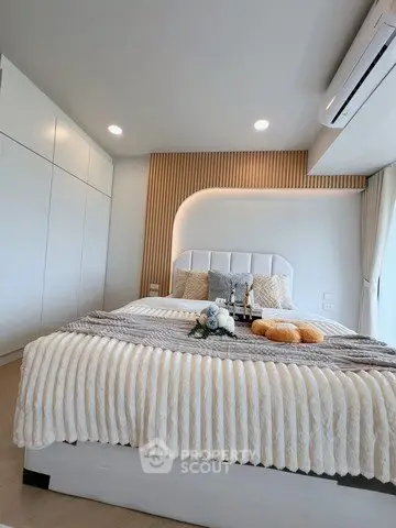 Modern bedroom with stylish decor and ample natural light, featuring a cozy bed and elegant design elements.