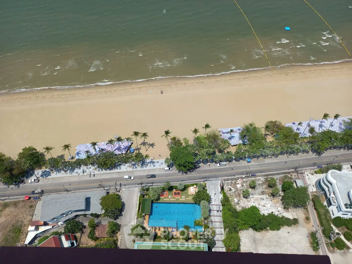 Stunning aerial view of beachfront property with pool and lush greenery, perfect for luxury living.