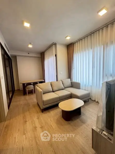 Modern living room with cozy sofa and natural light, perfect for relaxation and entertaining.