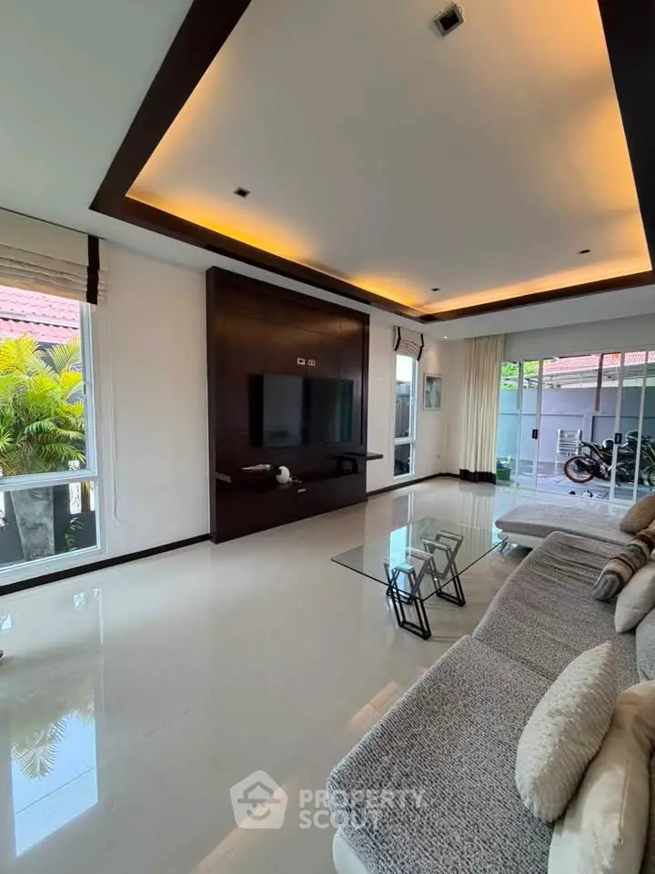 Spacious modern living room with sleek design and large windows offering natural light.