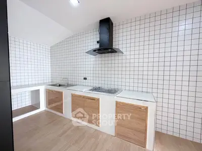 Modern kitchen with sleek wooden cabinets and stylish black range hood