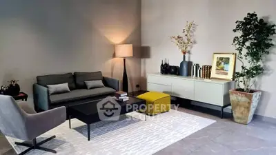 Modern living room with stylish furniture and elegant decor, featuring a cozy sofa, armchair, and decorative plants.
