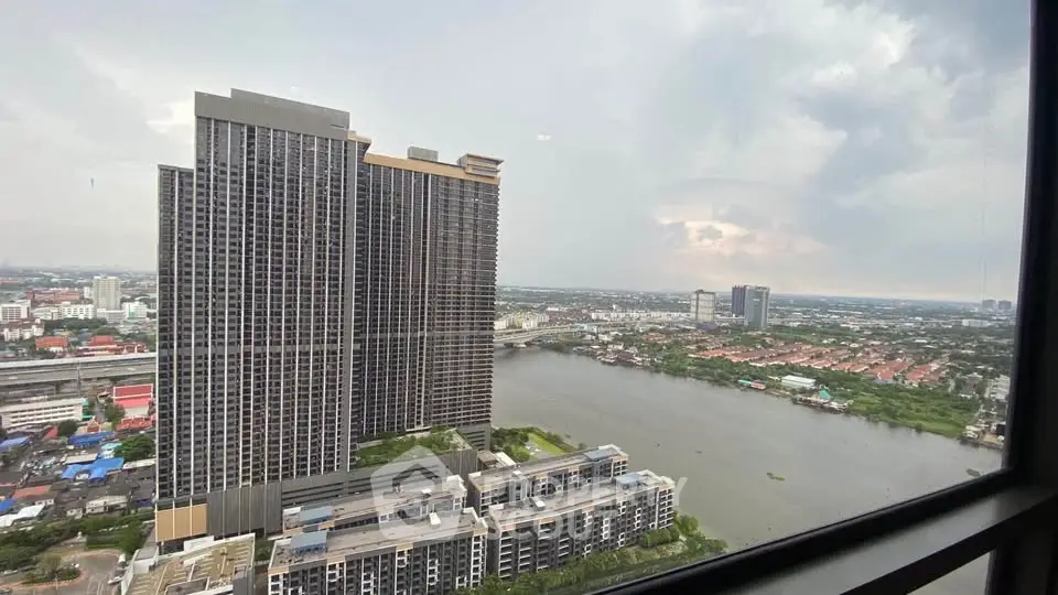 Stunning riverfront high-rise view with expansive cityscape and lush greenery.