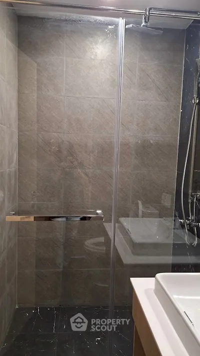 Modern bathroom with glass shower enclosure and sleek fixtures.