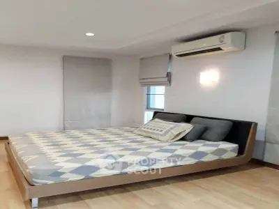 Modern bedroom with stylish bed and air conditioning in a cozy apartment.