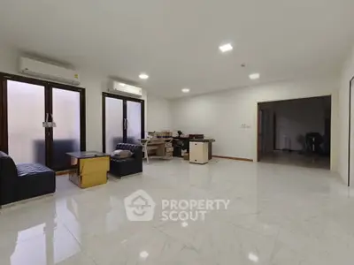 Spacious living room with modern furniture and large windows, perfect for family gatherings.