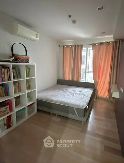 Cozy bedroom with natural light, wooden flooring, and ample storage space.