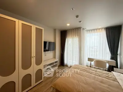 Modern bedroom with large windows and stylish furniture in a high-rise apartment.