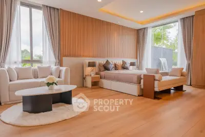 Luxurious bedroom with elegant decor and large windows offering natural light.
