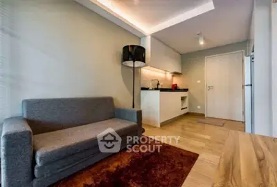 Modern living room with sleek kitchen and cozy sofa in open layout apartment.