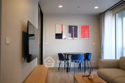 Modern living room with stylish decor and wall art, featuring a cozy seating area and dining table.