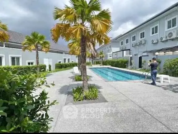 Modern residential complex with swimming pool and lush landscaping.