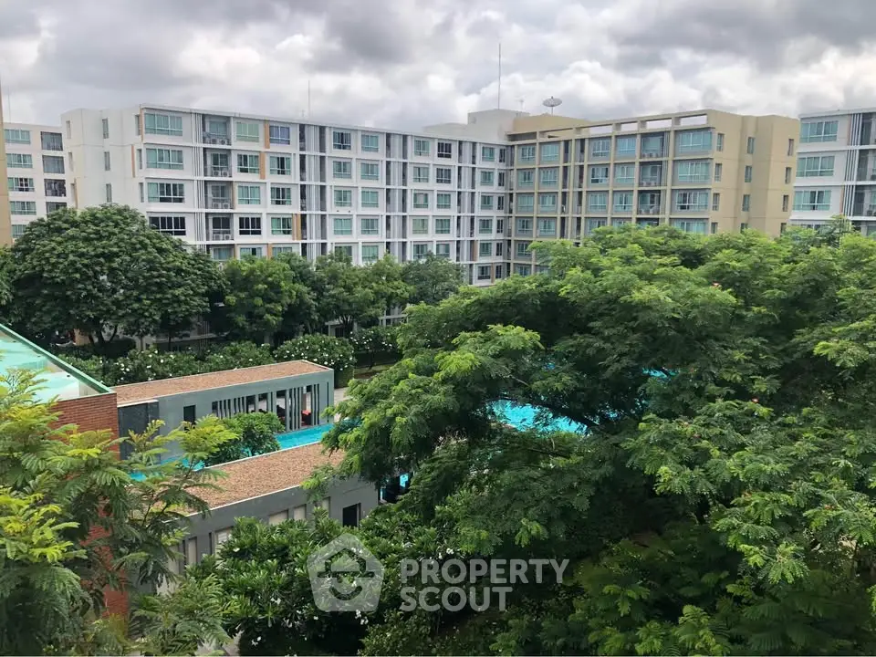 Modern apartment complex with lush greenery and pool view