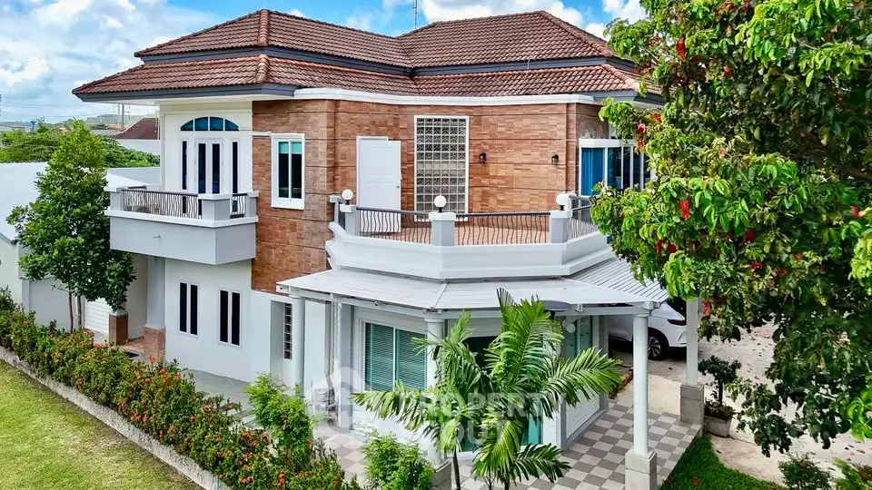 Stunning two-story house with brick facade and lush garden