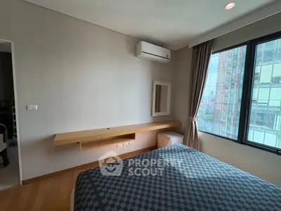 Modern bedroom with large window and air conditioning in urban apartment