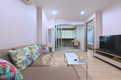Modern living room with stylish decor and open layout, featuring a cozy sofa and large TV.