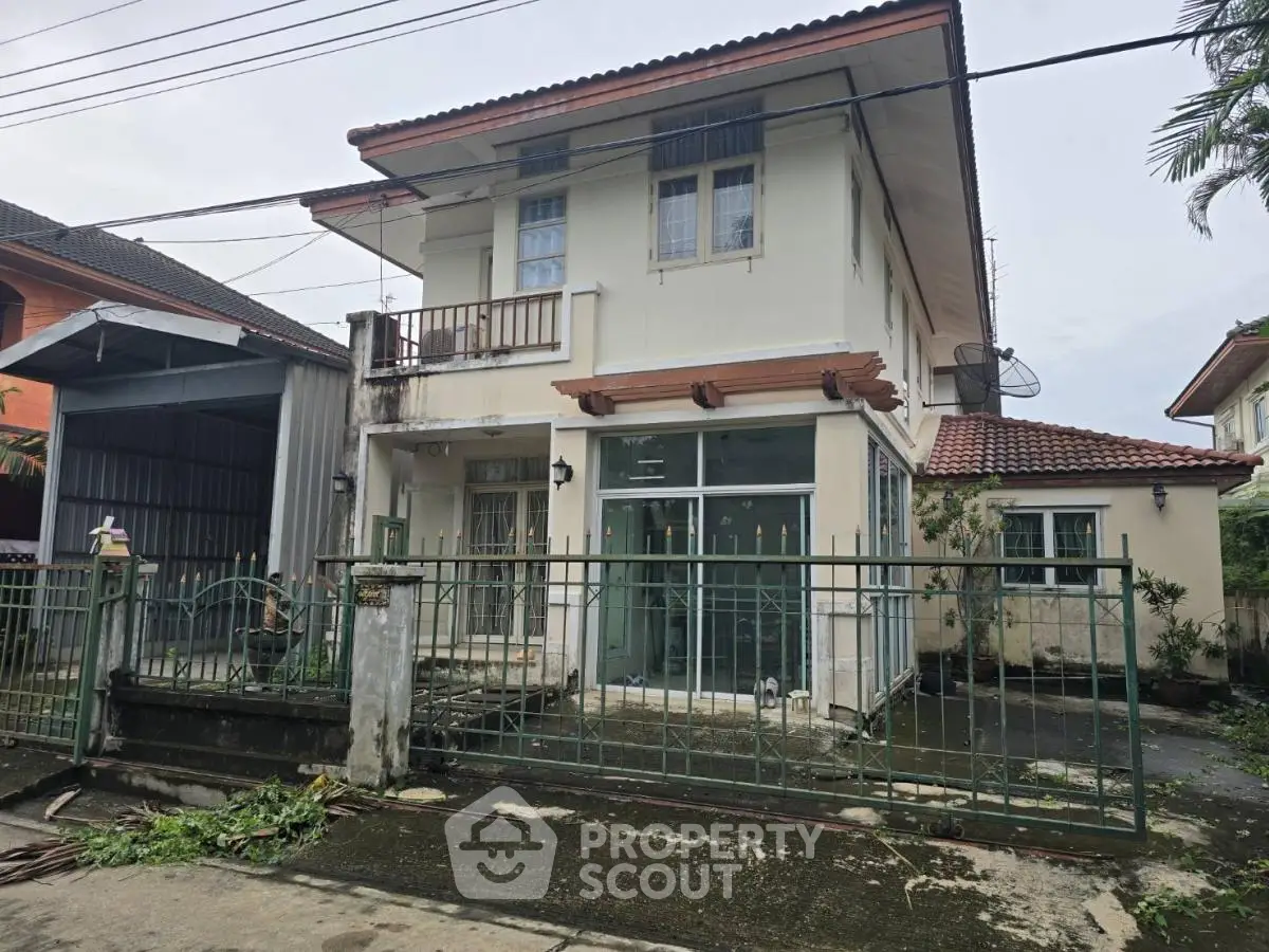 Charming two-story house with gated entrance and tiled roof in suburban neighborhood