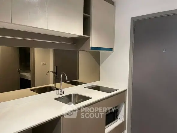 Modern compact kitchen with sleek cabinetry and built-in appliances