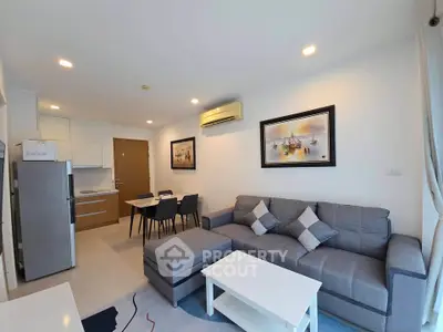 Modern living room with stylish decor and open kitchen layout in a cozy apartment.