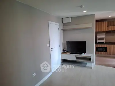 Modern living room with TV and stylish kitchen area in open layout apartment