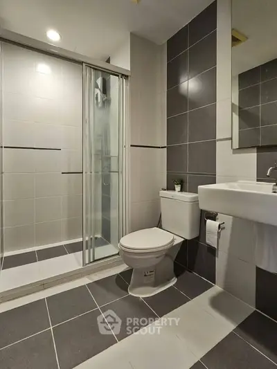 Modern bathroom with sleek shower and stylish tiles, perfect for contemporary living.