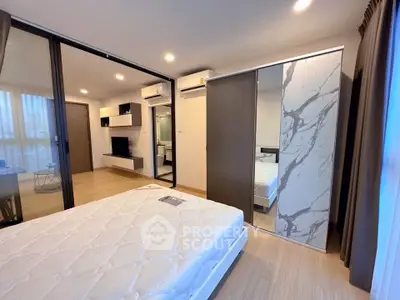 Modern bedroom with sliding glass doors and stylish decor in a contemporary apartment.