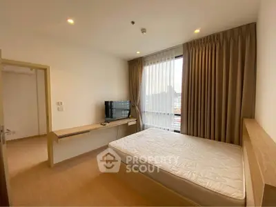 Modern bedroom with large window and natural light in a stylish apartment.