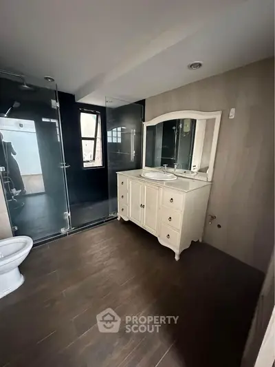 Spacious modern bathroom with elegant vanity and glass shower enclosure