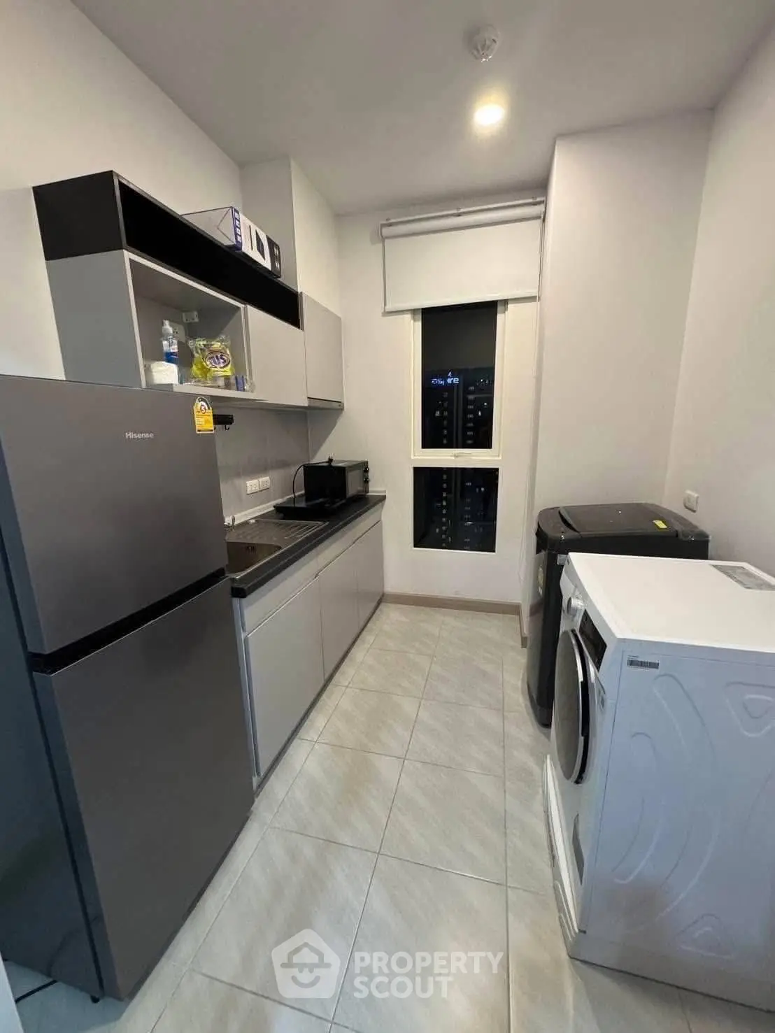 Modern kitchen with sleek appliances and ample storage in a contemporary apartment.