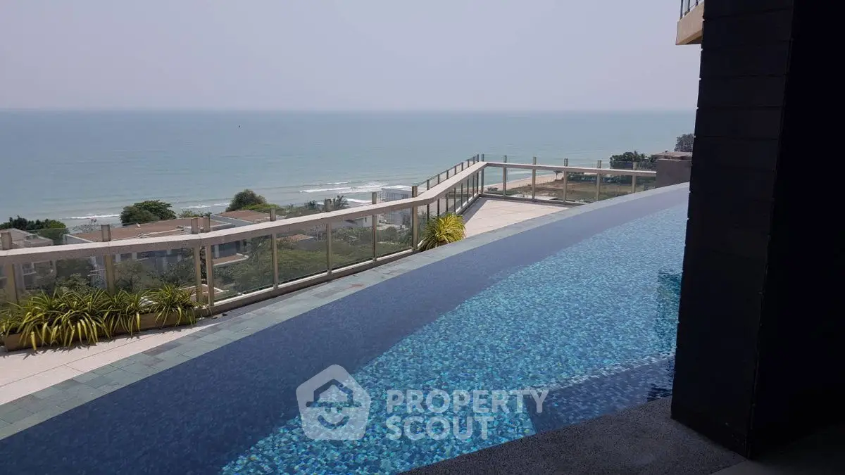 Stunning ocean view from luxurious infinity pool on high-rise balcony.