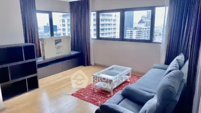 Spacious living room with city view, modern sofa, and wooden flooring.