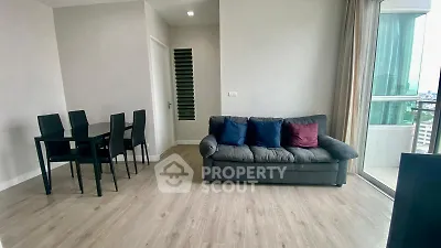 Modern living room with sleek furniture and city view balcony