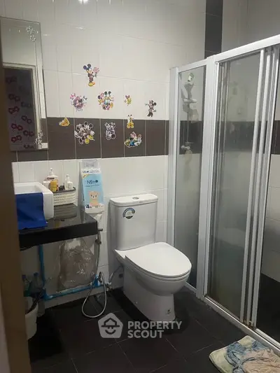 Charming bathroom with shower and playful wall decals, perfect for family living.