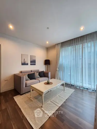 Modern living room with elegant decor and large windows for natural light.