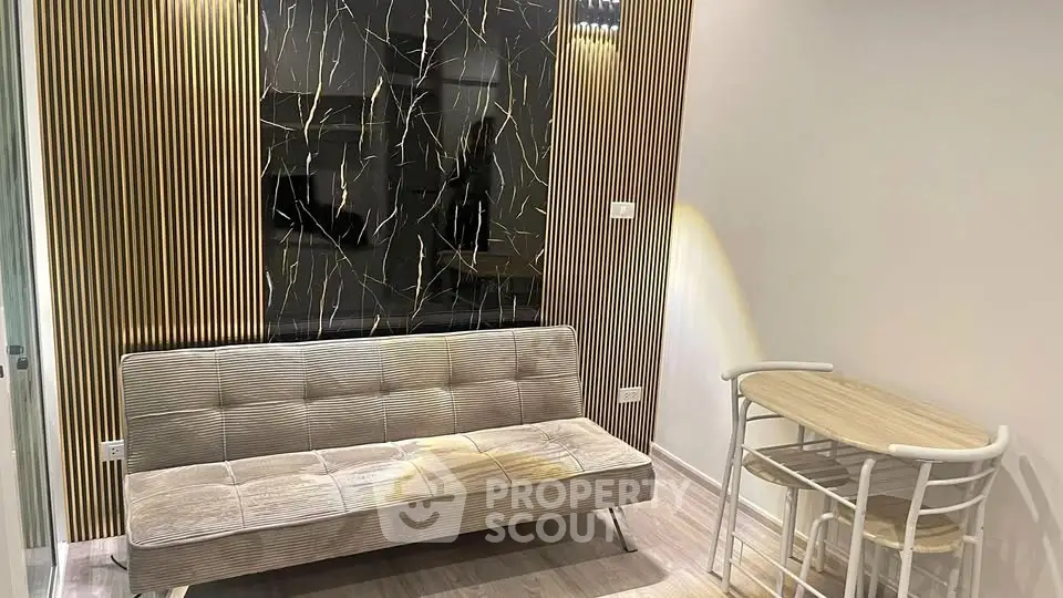 Modern living room with stylish sofa and chic dining set, featuring elegant wall design.