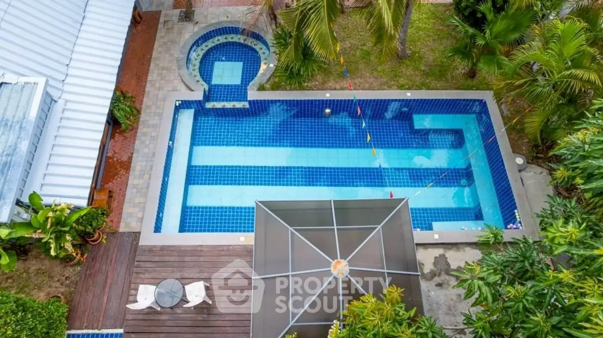 Stunning aerial view of a luxurious backyard pool with lush greenery and modern design.
