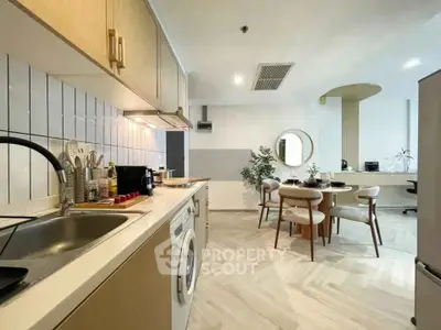 Modern kitchen with dining area, featuring sleek cabinetry and stylish decor.