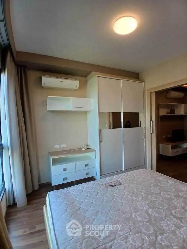 Cozy bedroom with modern wardrobe and air conditioning in a stylish apartment.