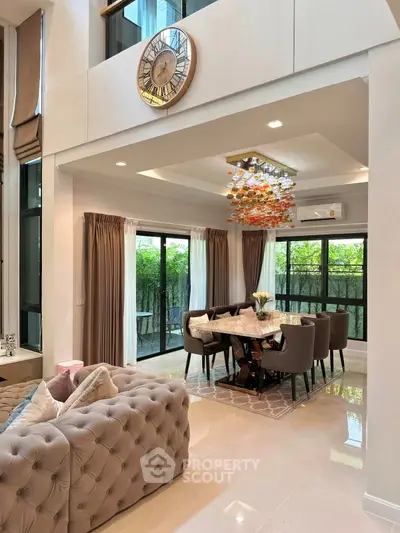 Luxurious open-plan living and dining area with elegant decor and large windows.