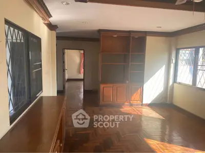 Spacious living room with wooden floors and built-in shelving