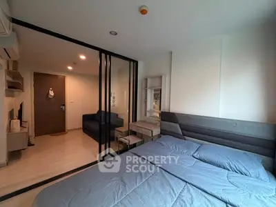 Modern bedroom with glass partition and cozy blue bedding in stylish apartment