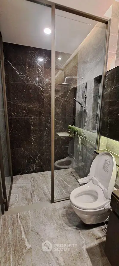 Luxurious modern bathroom with elegant marble tiles and glass shower enclosure.